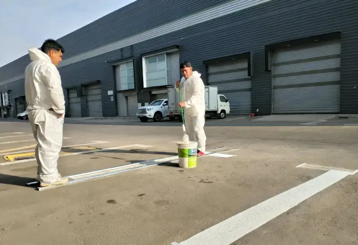 Equipo con trajes de protección demarcando un estacionamiento